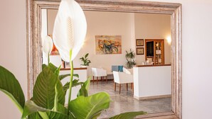 A modern interior with a dining area, a kitchen, and a living space. - Hotel Il Gabbiano (Alghero)