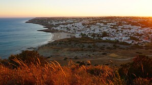 A coastal town with white buildings, a beach, and a hilly landscape. - Waterside Village - Sea View Apartment (Luz)