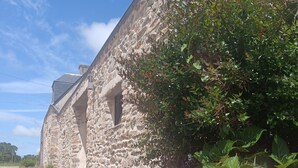 A stone building with a rustic appearance, a paved pathway, and pink hydrangea flowers in the foreground. - L'escale - Longère en Campagne 6 Voyageurs, 3 Chambres (Pouldreuzic)