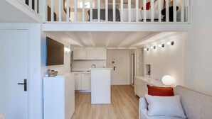A modern, compact apartment with a kitchenette, a dining area, and a living room with a sofa. - SUEDE PROMENADE – Duplex apartment at 1 min from the sea, 2 bathrooms (Nice)