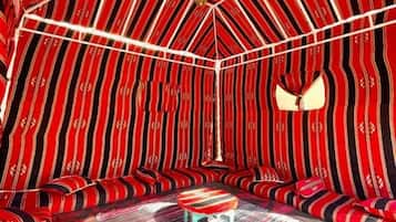 Una habitación con un diseño único de techo a rayas, una zona de estar central y un suelo estampado.