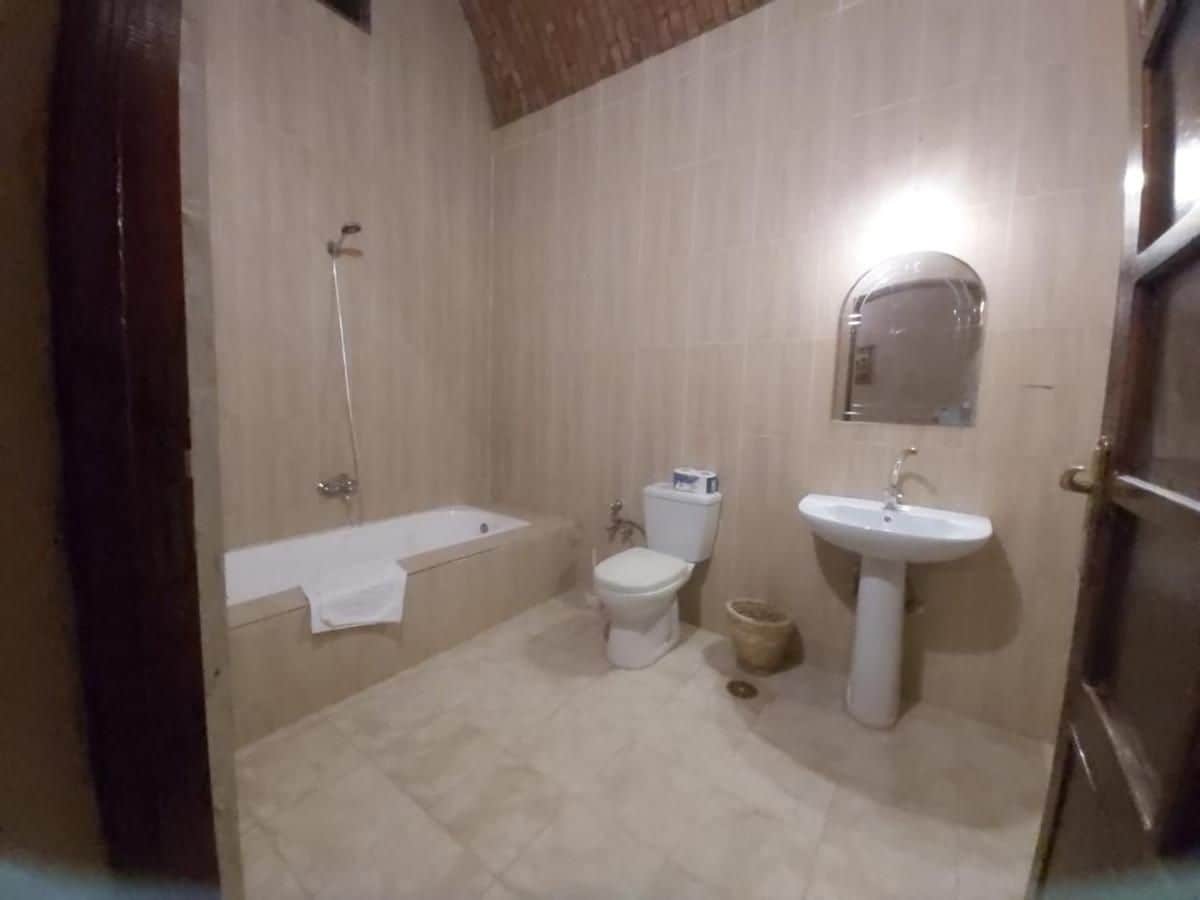 A bathroom with a bathtub, toilet, and sink.