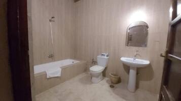 A bathroom with a bathtub, toilet, and sink.