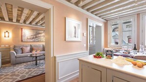 Una cocina moderna con encimera, un comedor con sofá y una sala de estar con mesa de centro.