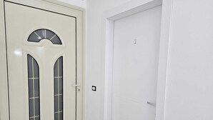 Une porte blanche avec une fenêtre en demi-cercle et une fenêtre plus petite en dessous.