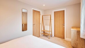 Une chambre à coucher avec un lit, une armoire en bois et une étagère en bois.