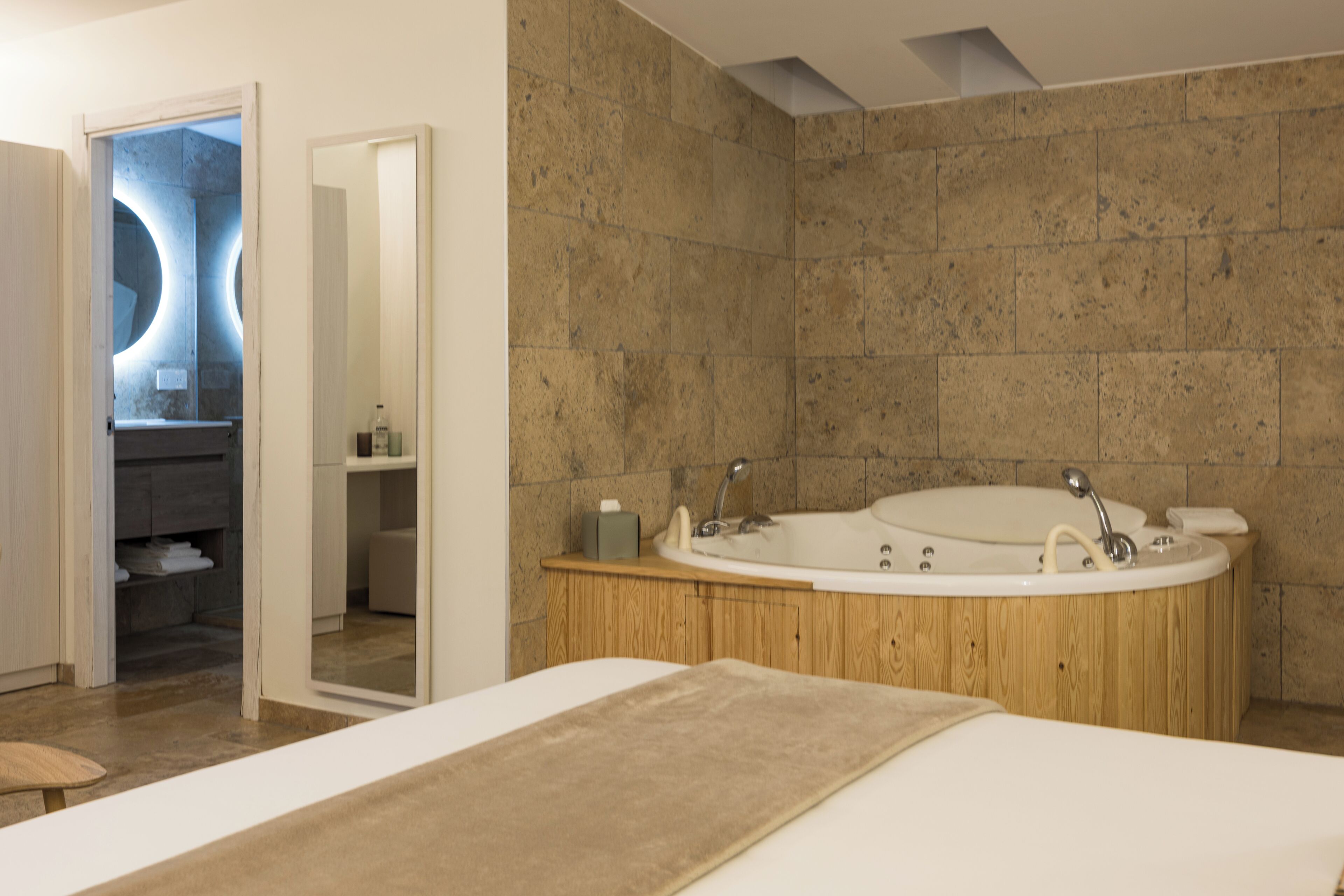 A modern bathroom with a freestanding bathtub, a wooden vanity, and a mirror.