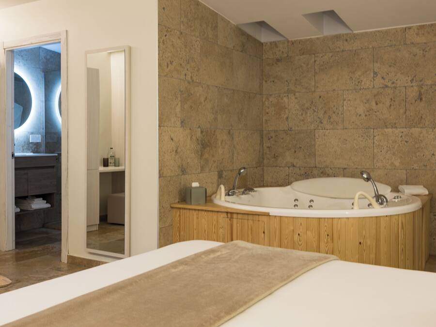 A modern bathroom with a freestanding bathtub, a wooden vanity, and a mirror.