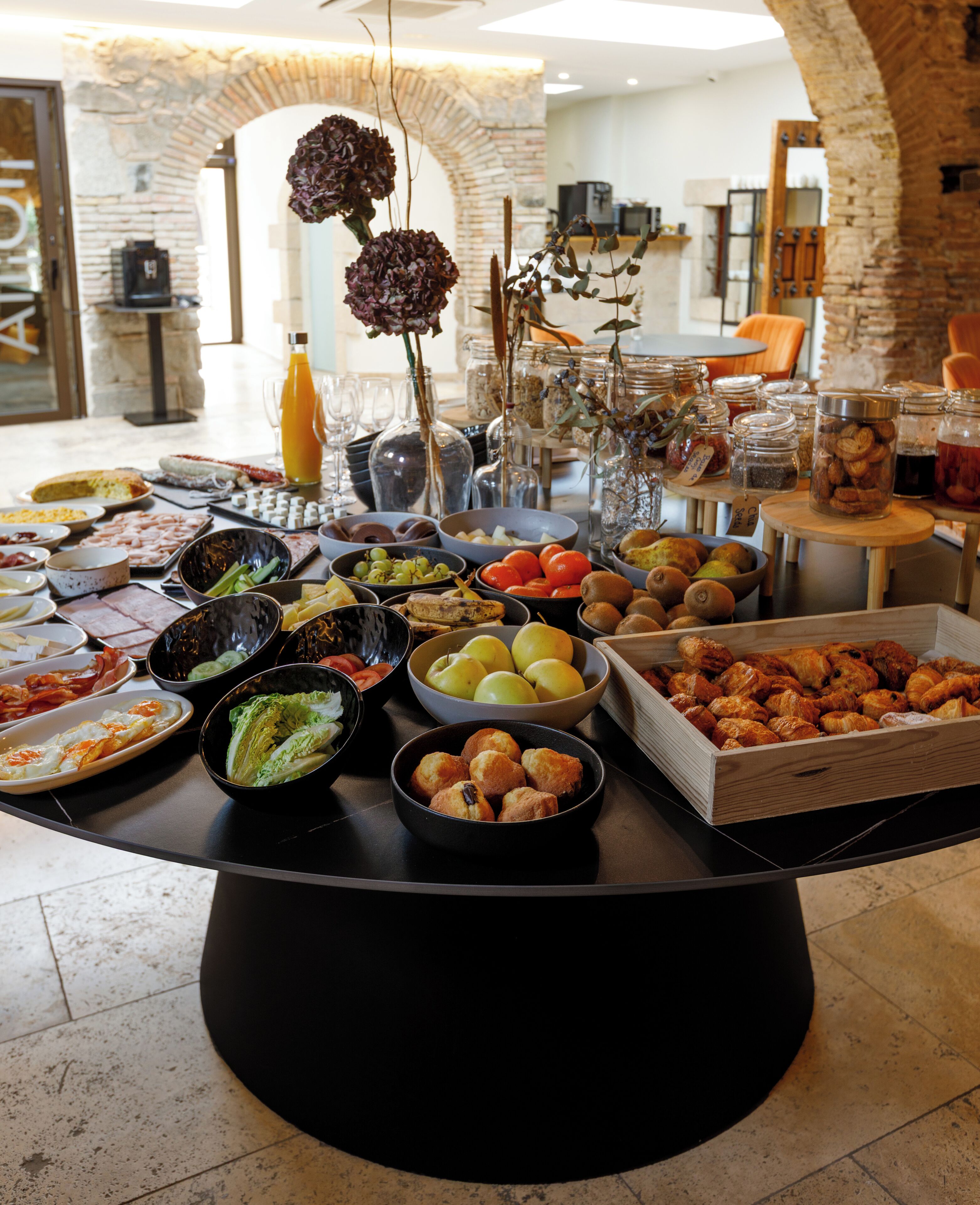 Une table de buffet garnie de divers plats et agrémentée d’un vase décoratif.