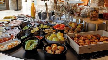 A buffet table with various food items and a decorative vase.