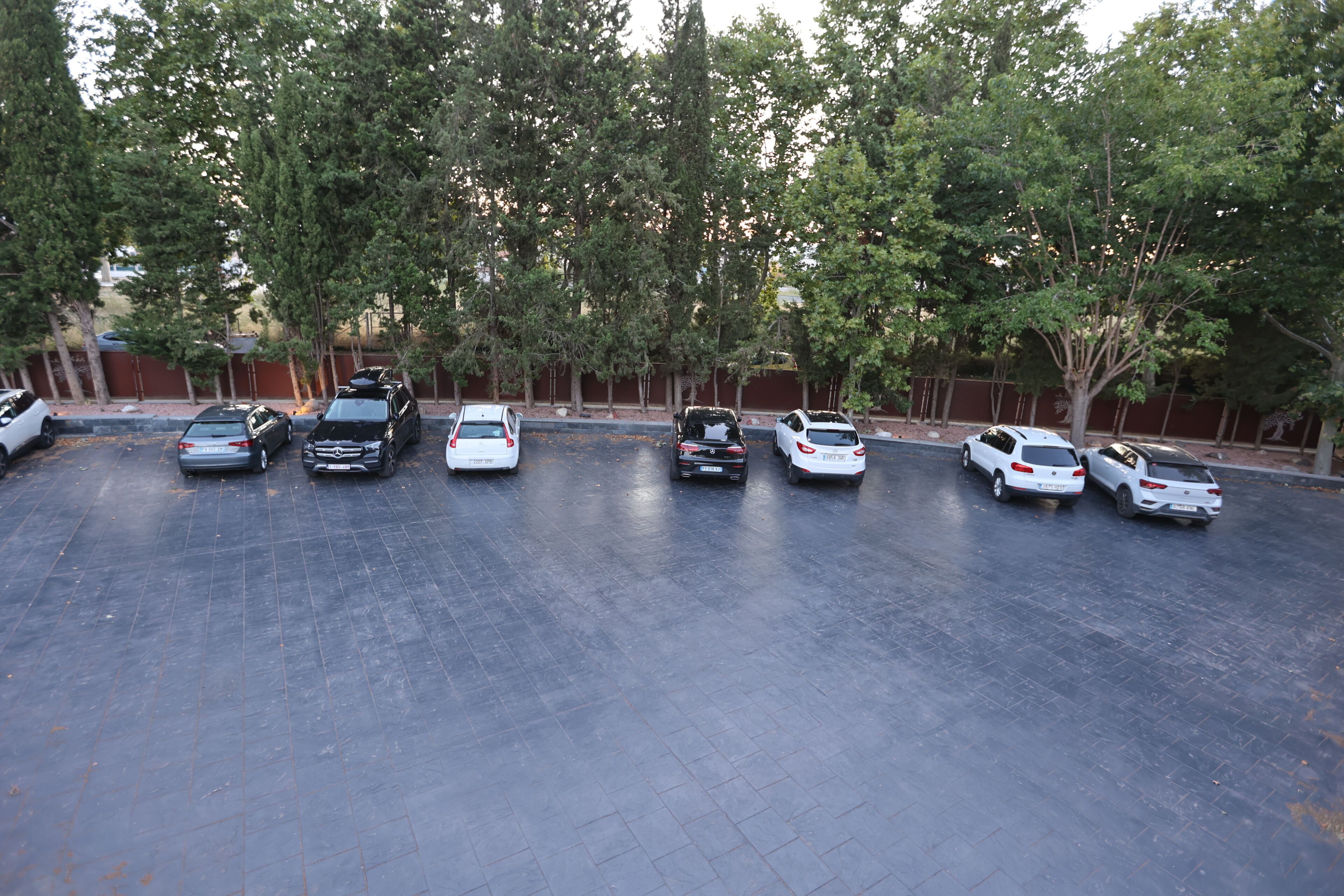 Un estacionamiento con varios coches aparcados.