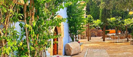 Un patio con suelo de baldosas, pilares de piedra y un bordillo amarillo.