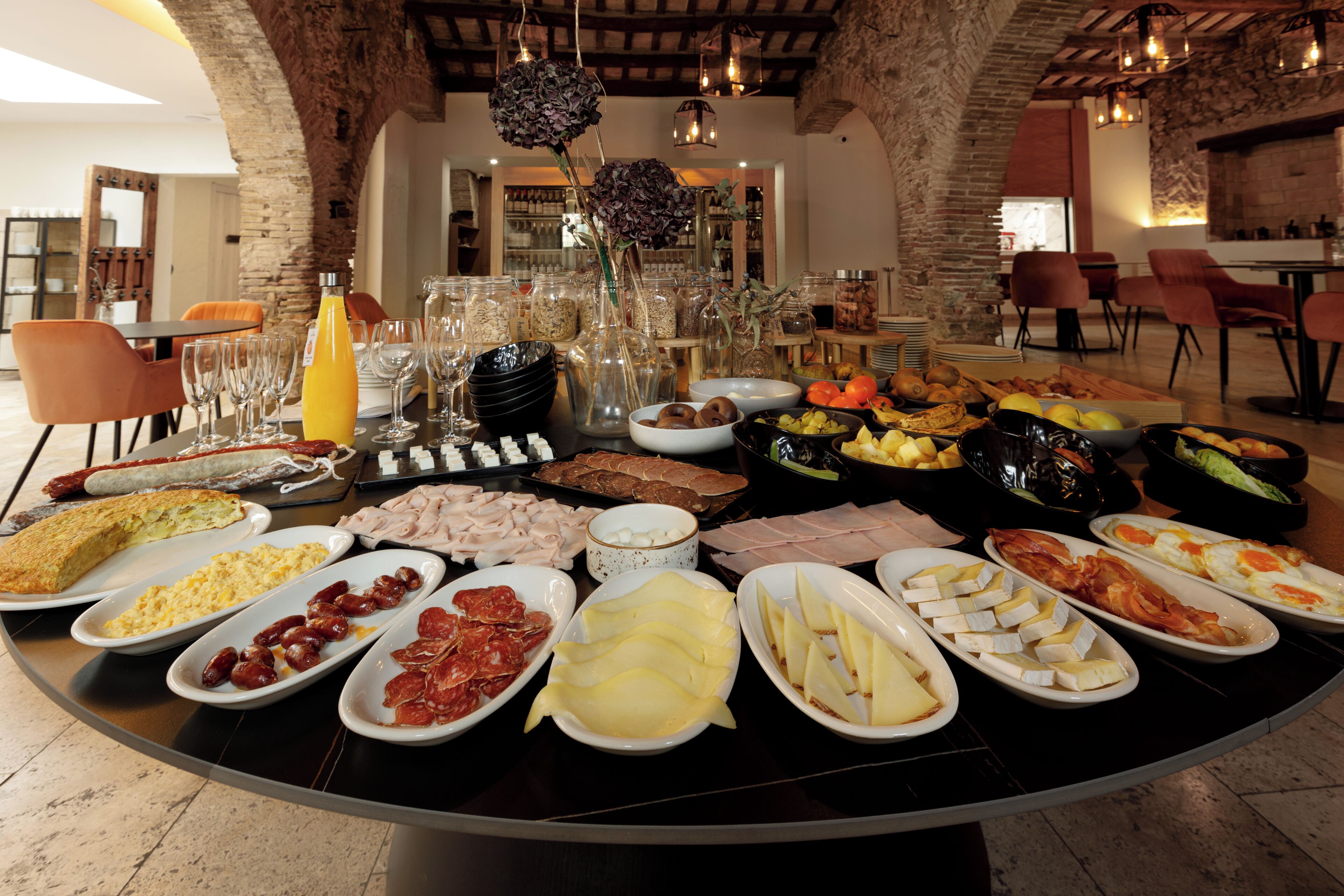 Una mesa de buffet con diversos alimentos y cristalería.