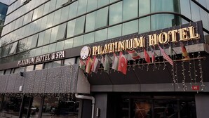 El exterior del Platinum Hotel & Spa, con un moderno revestimiento de vidrio y un cartel que muestra el nombre del hotel.