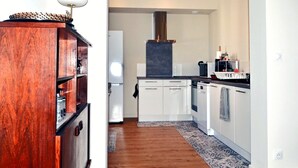 A modern kitchen with white cabinets, a built-in oven, and a range hood.