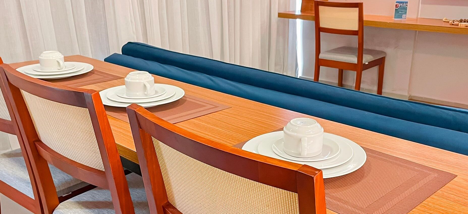 Un coin repas avec une table en bois, quatre chaises et un canapé bleu.