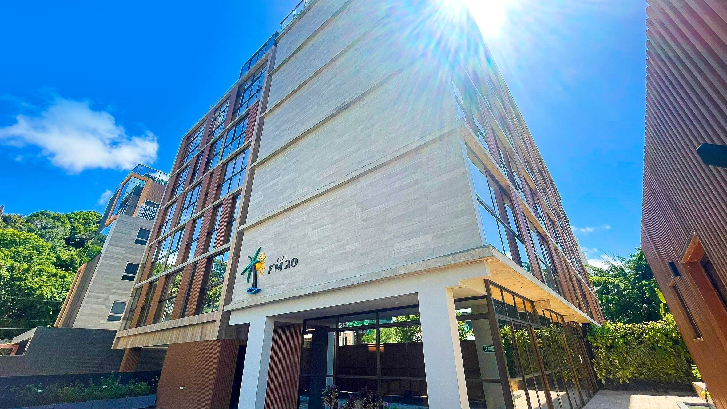 A modern building with a sign reading "FLAT FM2" and a logo.