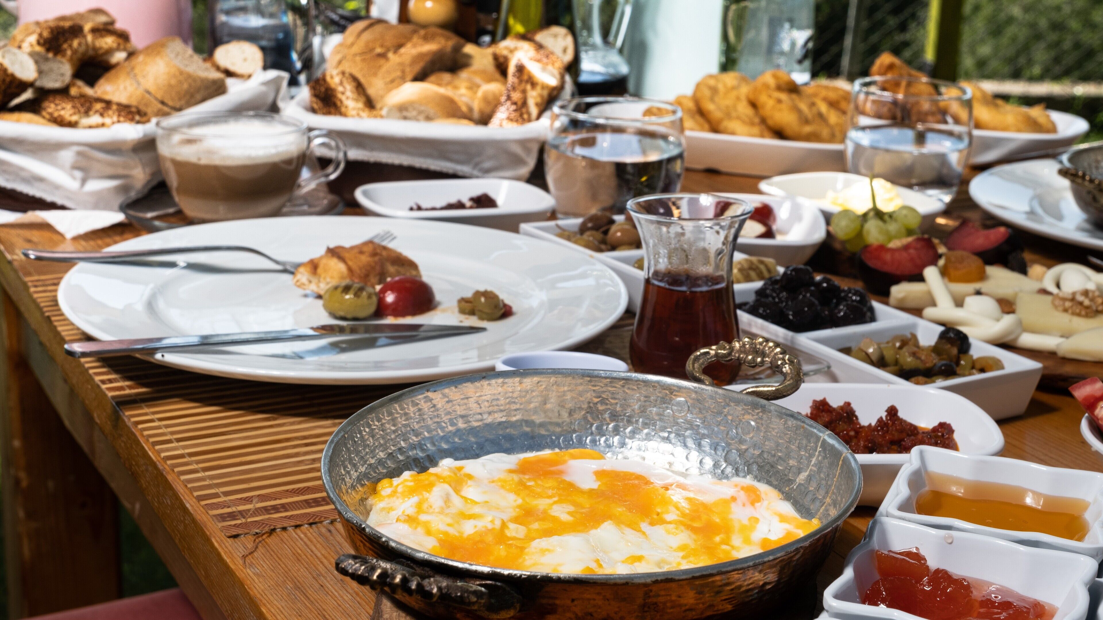 Un bufé de desayuno con diversos platos, como huevos, pan y frutas.