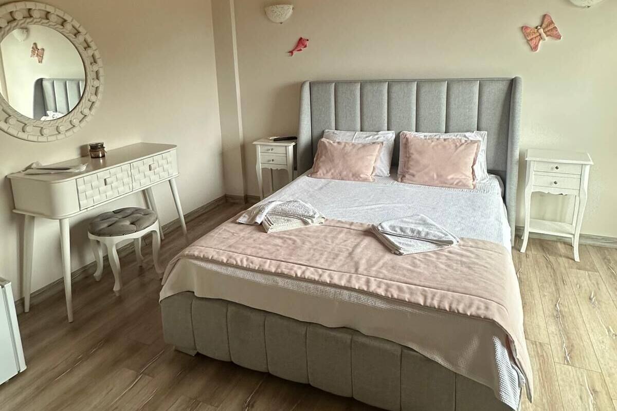 Un dormitorio con una cama grande, un aparador, un tocador y un espejo.
