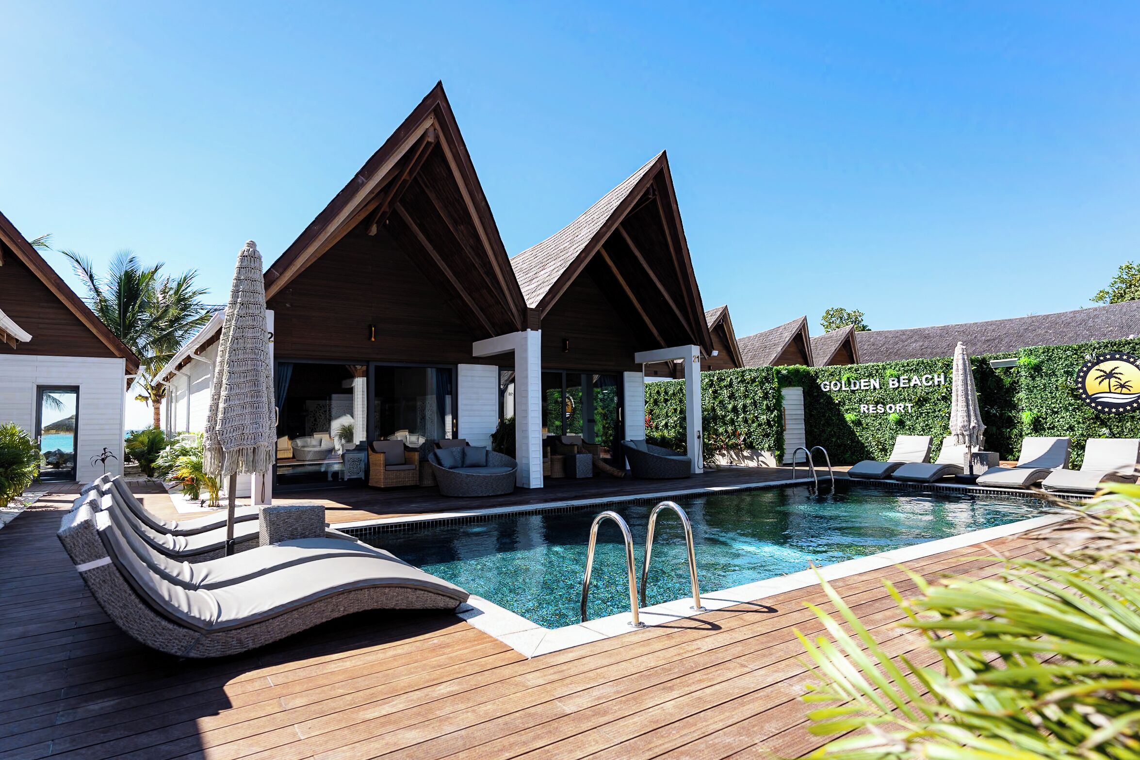 Un resort con piscina, sillas de descanso y una zona de estar techada.