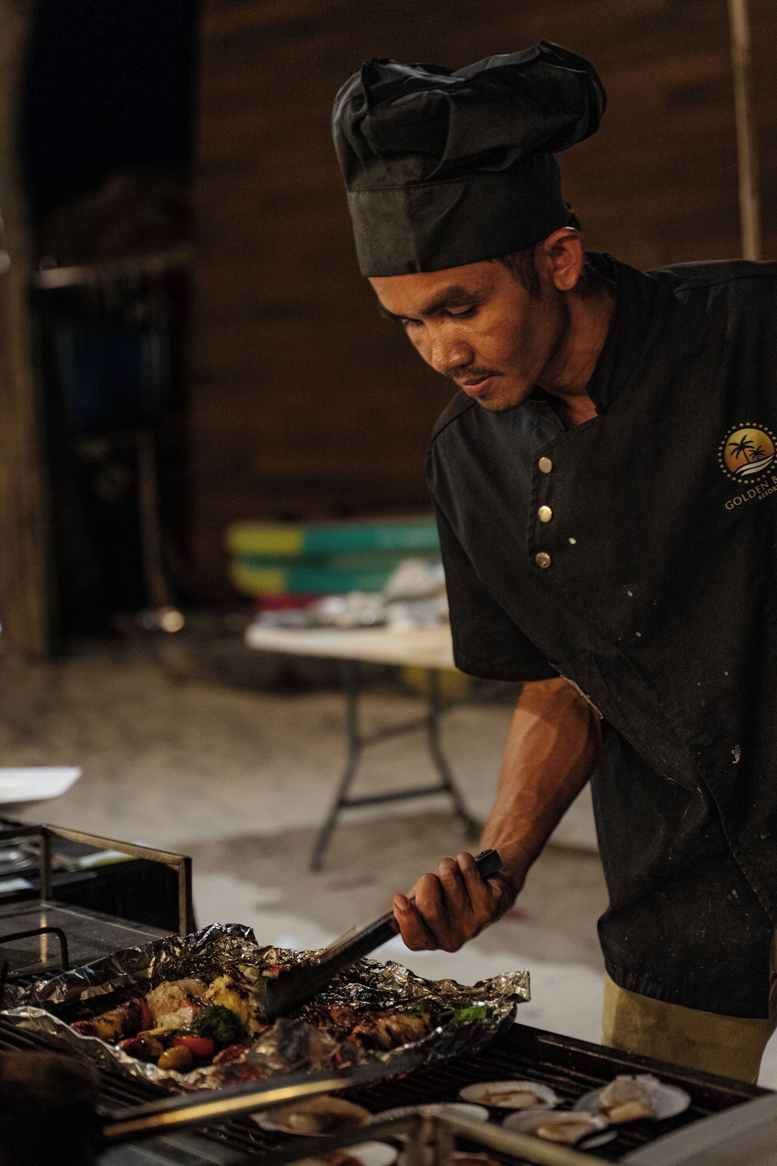 A chef grilling food on a barbecue.