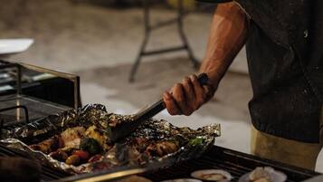 A chef grilling food on a barbecue.