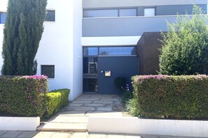 Stylish entrance with a glass door and beautifully manicured gardens.
