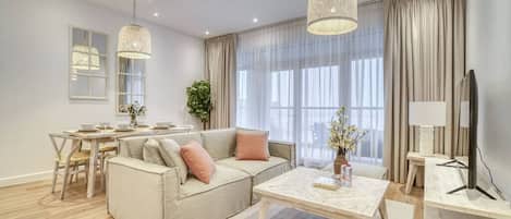 A modern living room with a sofa, coffee table, and dining area.