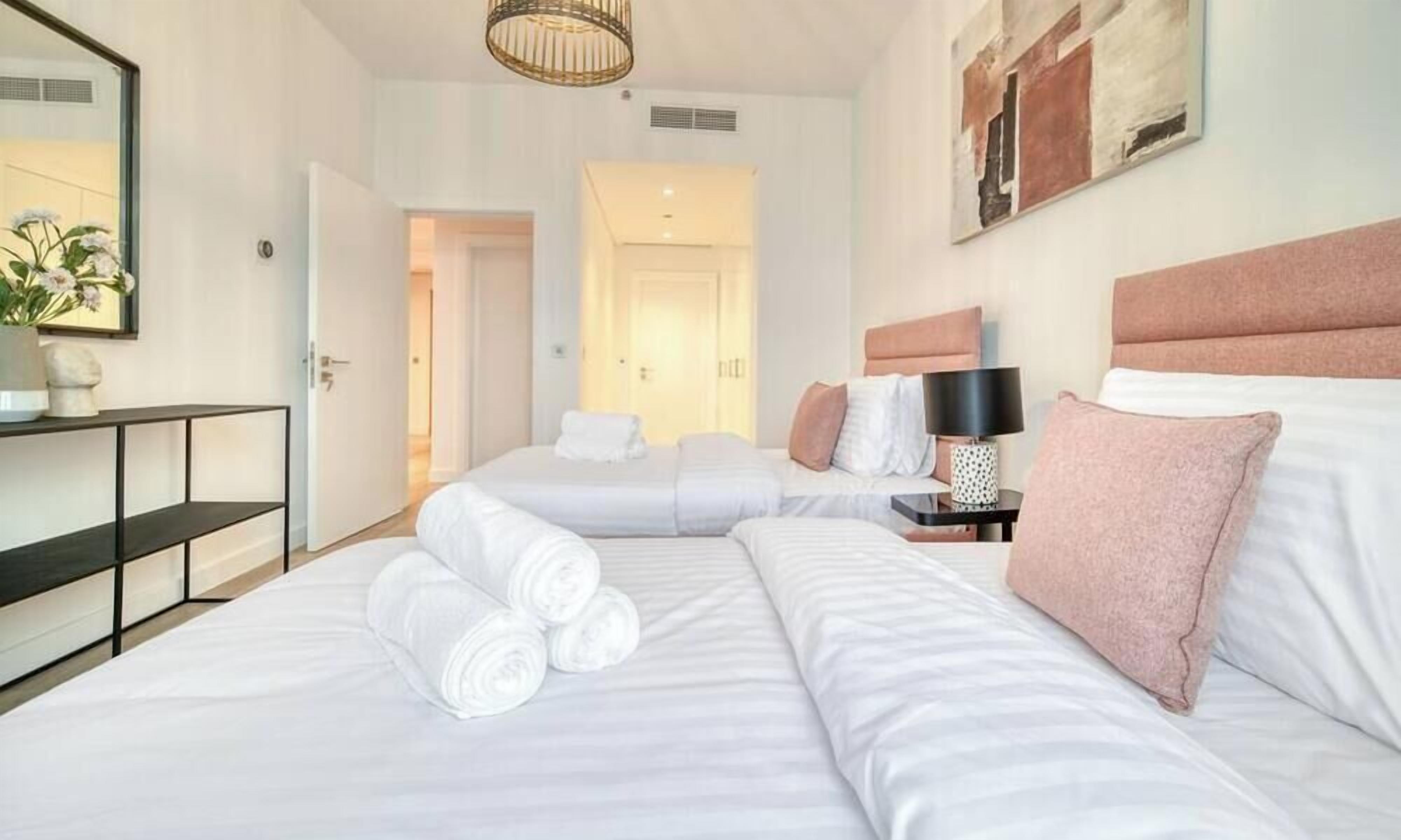 Camera d'albergo con due letti, un comodino con una lampada e uno specchio grande.