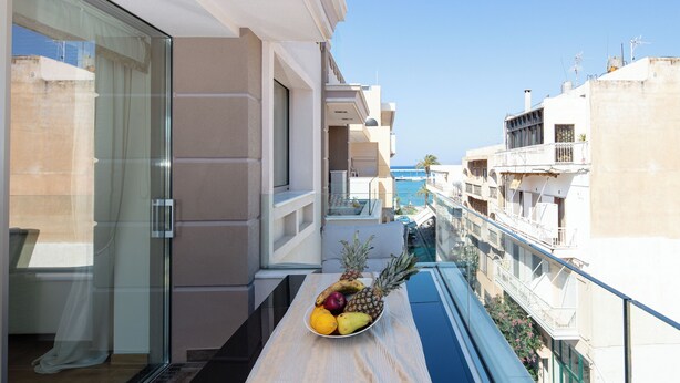 A balcony with a fruit bowl and a view of the sea. - DeMaNi President Suites (Sitia)
