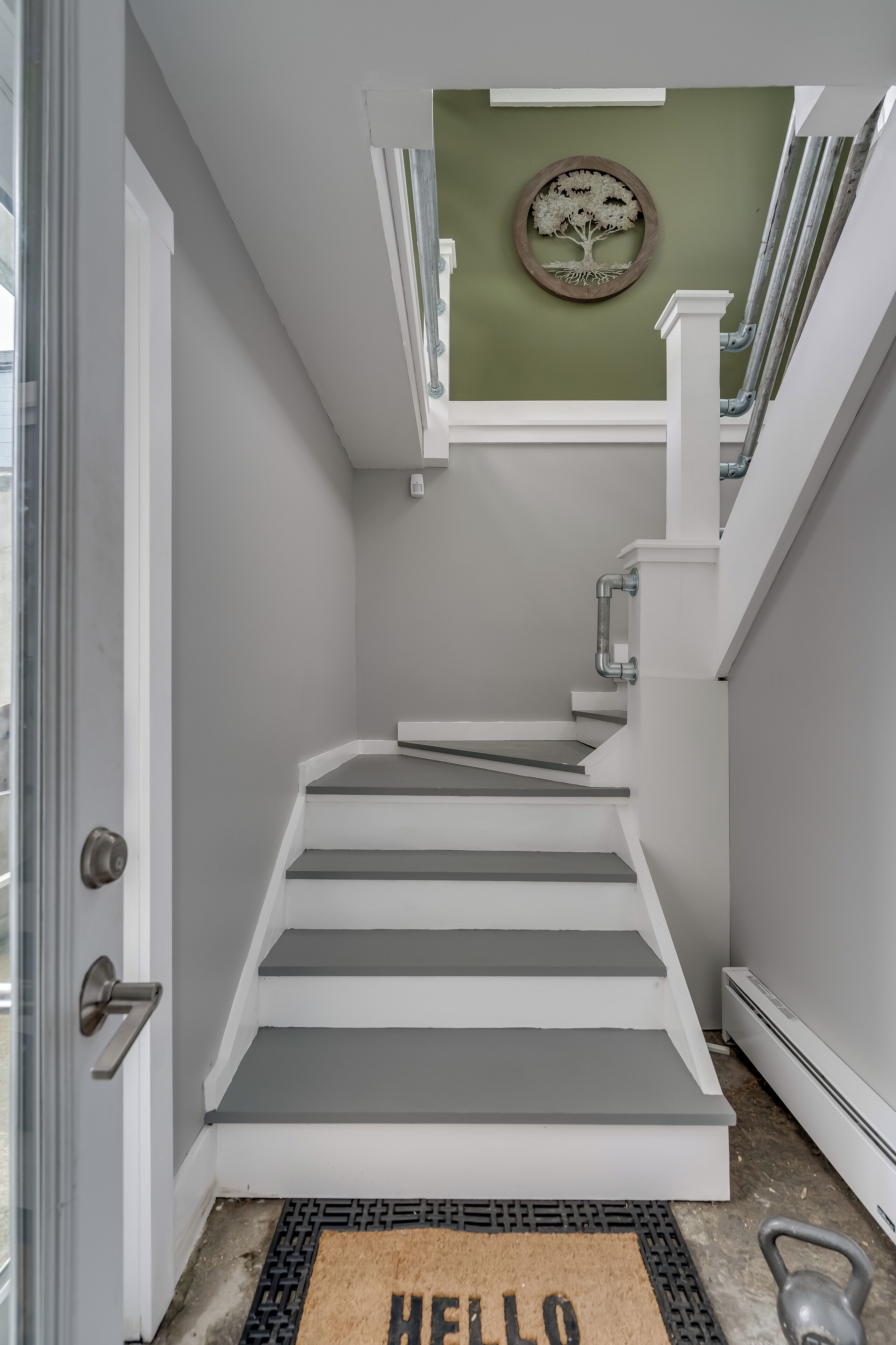 A staircase with white steps and a green wall.