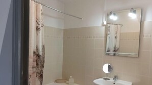 Ein Badezimmer mit Badewanne, Waschbecken und Spiegel.