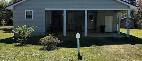 A single-story house with a porch, a mailbox, and a garage.