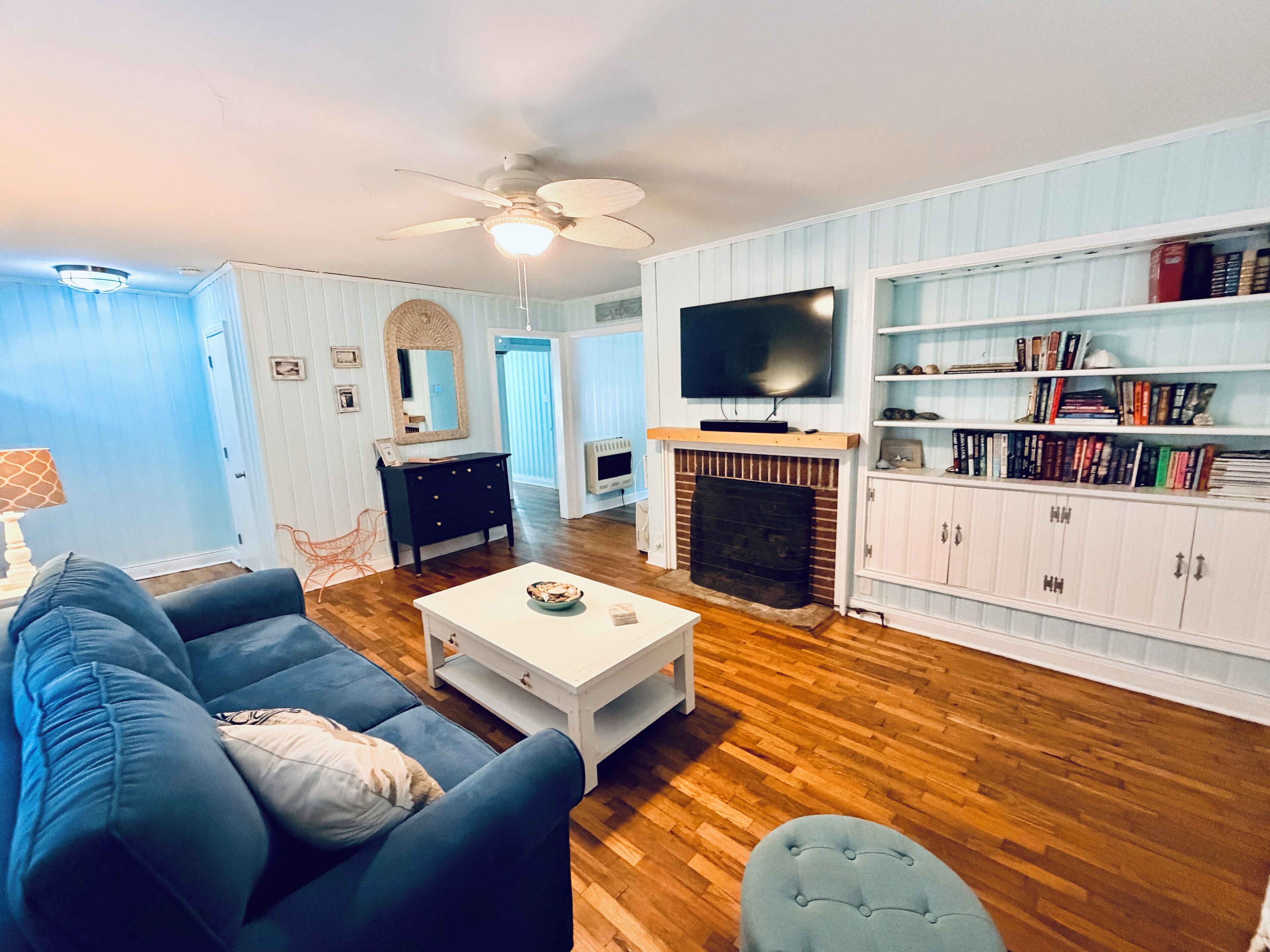 TV connectée, cheminée, livres, chaîne hi-fi