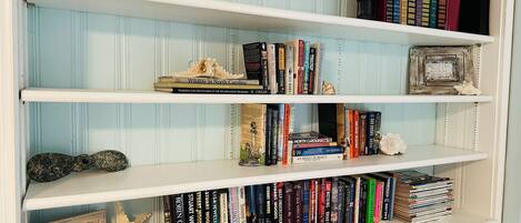 Una estantería con varios libros y objetos decorativos.