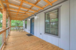 A covered porch with wooden beams, a blue door, and a window. - Cates Cottage-8 Mins to Downtown Fred! (Fredericksburg)