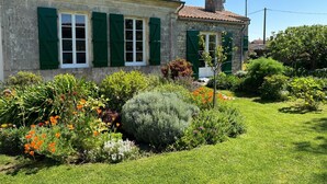 Un bâtiment en pierre avec des volets verts et un toit en tuiles.