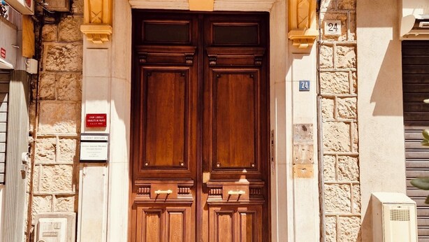 Puertas de madera dobles con fachada de piedra, un cartel que dice 'Union Libérale Israélite de France' y el número '24' en la pared.