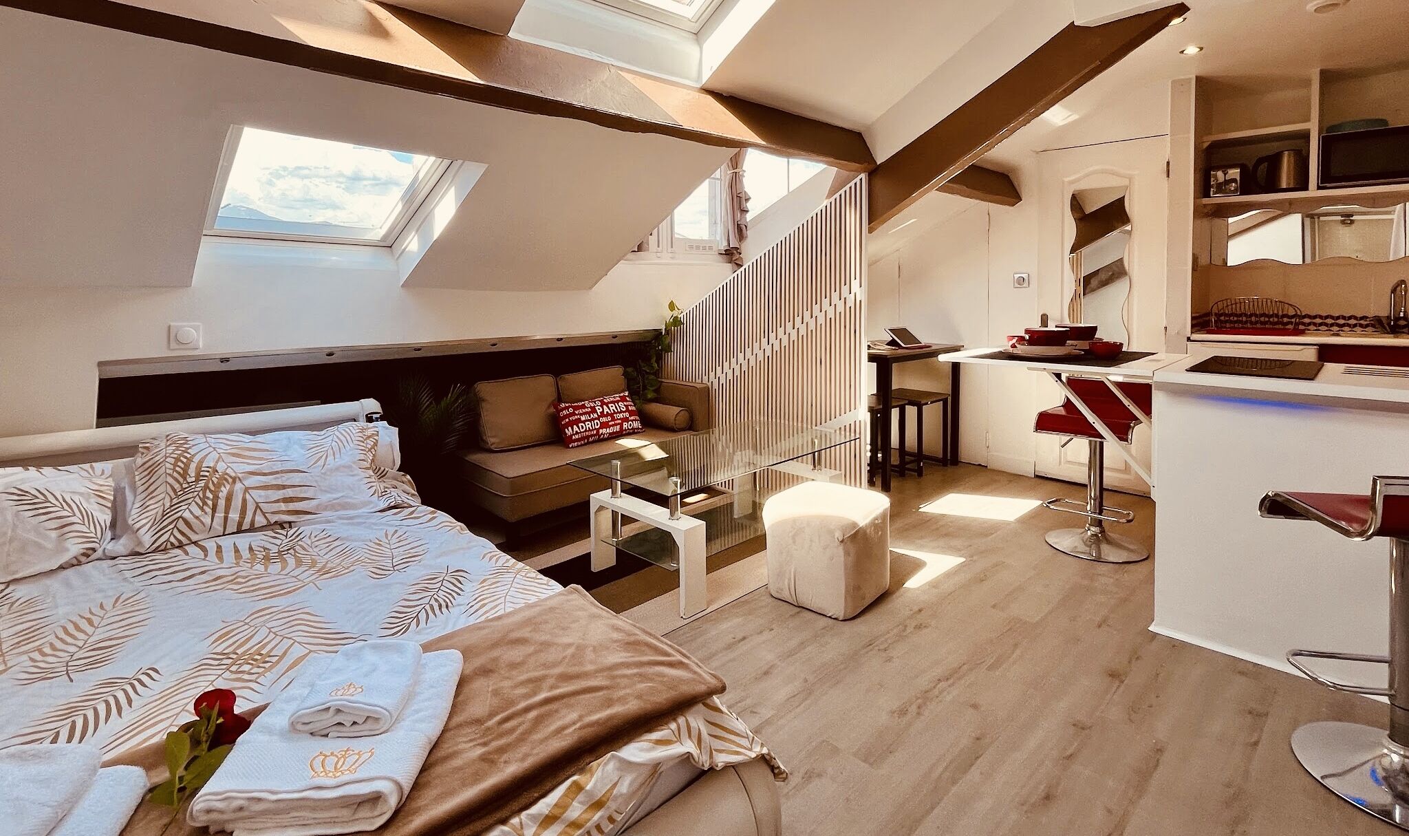 Ein modernes Loft-Schlafzimmer mit einem großen Bett, einer Sitzecke und einer Küchenzeile.