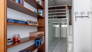 Un pasillo moderno y limpio con estanterías de madera llenas de libros y un cartel que dice 'Por favor, retire mis cosas'.