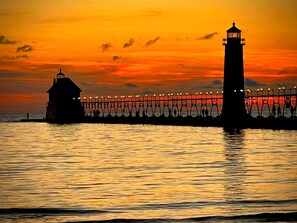 A pier with a lighthouse and a small building, extending into the water. - Spacious Spring Lake Retreat • Beach Access • Sleeps 8 • Family & Pet Friendly (Spring Lake)