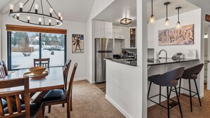 A modern kitchen with a central island, stainless steel appliances, and pendant lighting. - Hidden Creek by Park City Vacations (Park City)