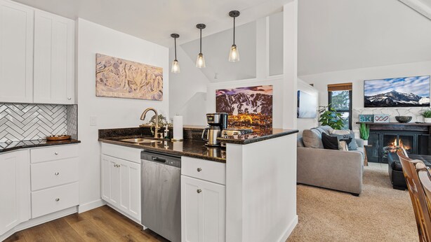 A modern kitchen with white cabinets, a herringbone backsplash, and pendant lighting. - Hidden Creek by Park City Vacations (Park City)