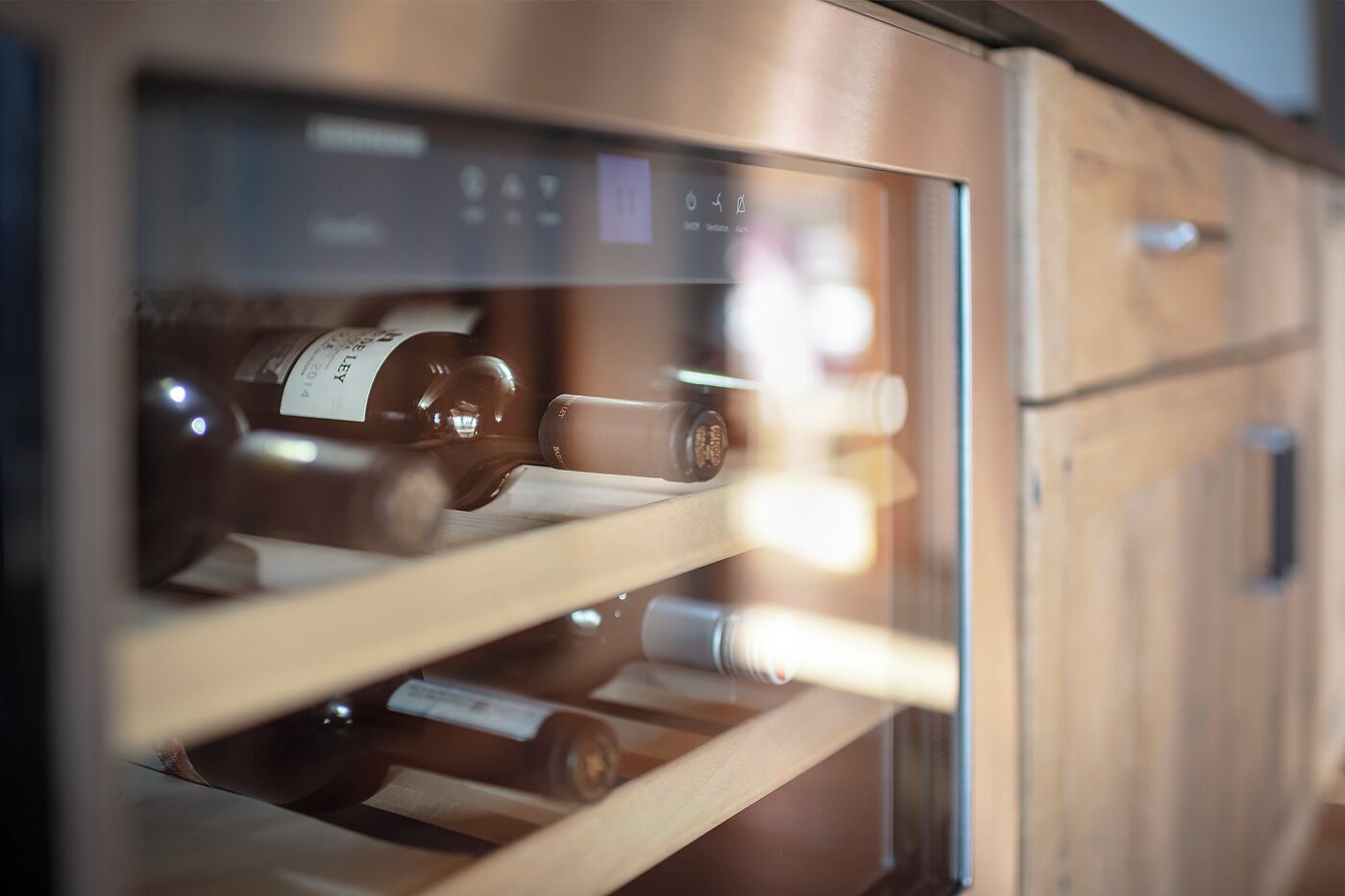 A wine refrigerator with multiple shelves containing bottles.
