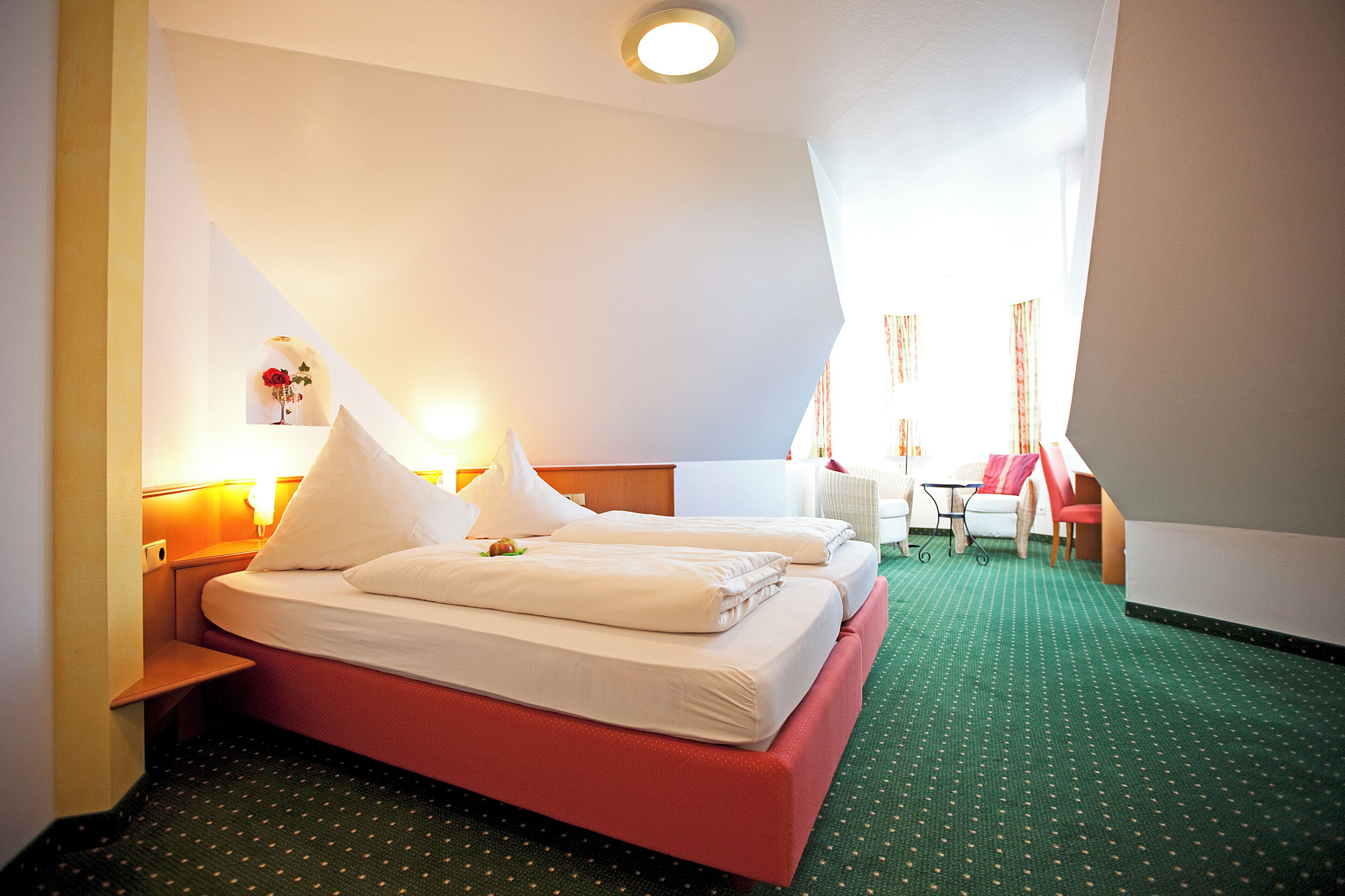 Ett hotellrum med två sängar, ett skrivbord och en stol.