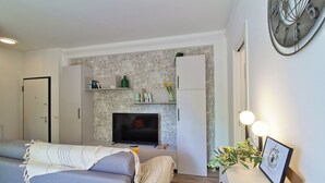 A modern living room with a sofa, television, and decorative items.