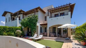 A two-story house with a patio area, outdoor furniture, and a barbecue grill. - Junior Villa AA02 - Zeus (Kouklia)