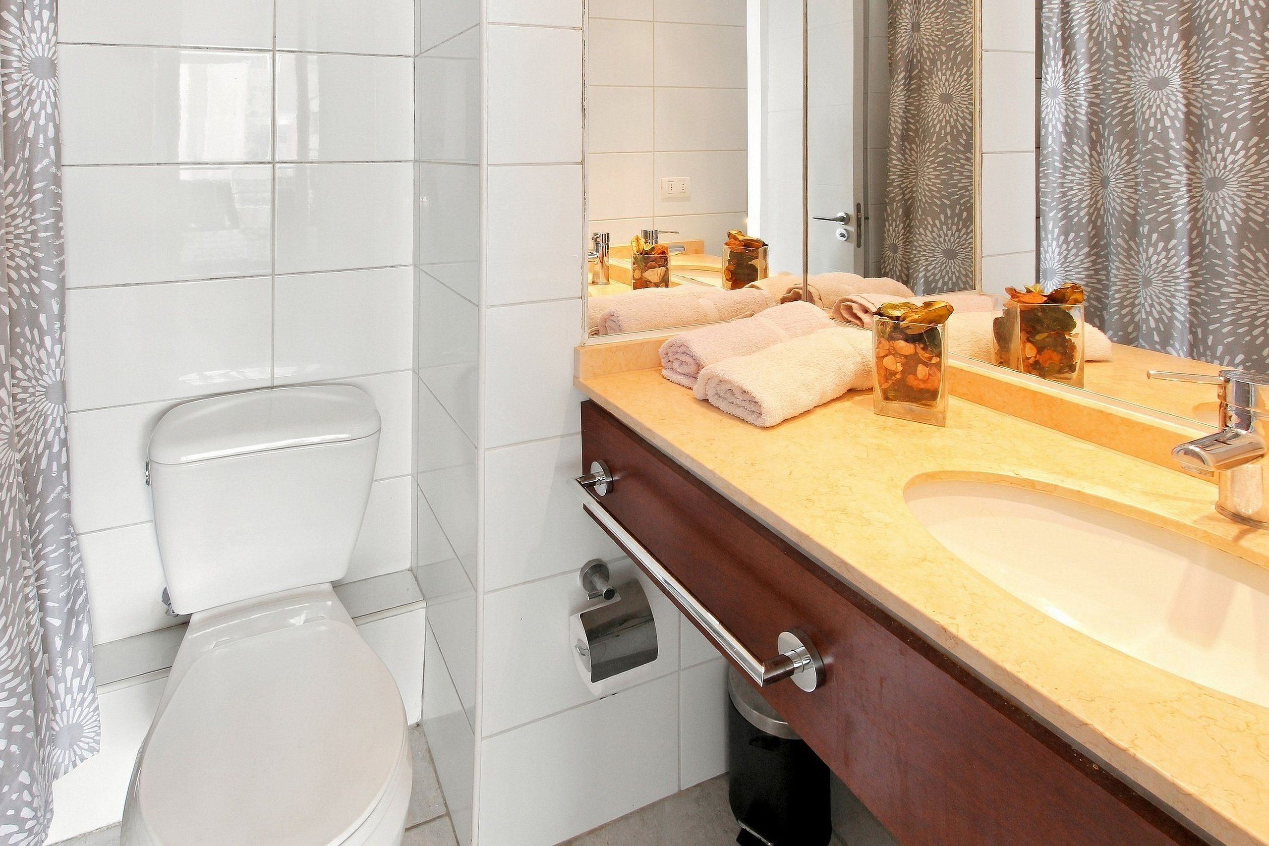 Un baño con inodoro, lavabo y espejo.