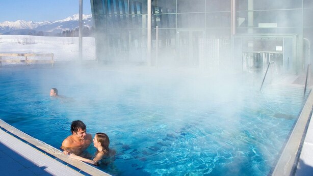 A hot spring pool with a glass enclosure, surrounded by snow and mountains. - Traum-ferienwohnung mit Dachterrasse & Tollem Ausblick, Cron4 Schwimmbad & Sauna (Brunico)