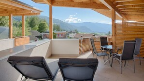A covered outdoor seating area with wooden beams and a view of mountains. - Traum-ferienwohnung mit Dachterrasse & Tollem Ausblick, Cron4 Schwimmbad & Sauna (Brunico)